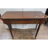 An early 19th century mahogany D end foldover top tea table over a dummy drawer, raised on turned