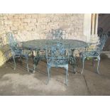 A green painted cast aluminium garden terrace table of oval form with decorative pierced foliate