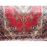 Hammadan type rug with typical central navy blue medallion, floral sprays, upon a red ground, 290