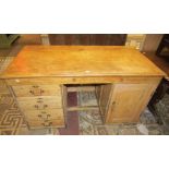 A 19th century stripped and waxed pine kneehole writing desk, to one side four drawers, to the other