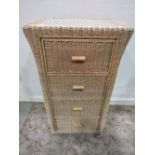 A contemporary wicker four drawer pedestal chest with inset glass top, with four framed prints after