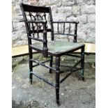 A Regency Sussex type elbow chair with faux bamboo detail, rush seat and later painted finish (