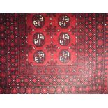 Bokhara rug with geometric medallions upon a red ground, 150 x 100cm