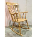 A contemporary Windsor beechwood lathe back rocking chair, with turned supports and stretchers