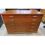 A vintage pitch pine plan chest of five long graduated drawers with tapered oak cup handles, flanked