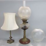 A brass oil lamp with glass font and twin burner, globe and chimney, together with an Edwardian