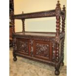 A Victorian oak buffet, the lower section enclosed by two carved and panelled doors, with lion mask,