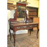 An Edwardian mahogany dressing table fitted with two frieze drawers on shaped supports, with