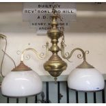 A hollow brass two branch hanging ceiling light with knopped stem supporting two scrollwork branches