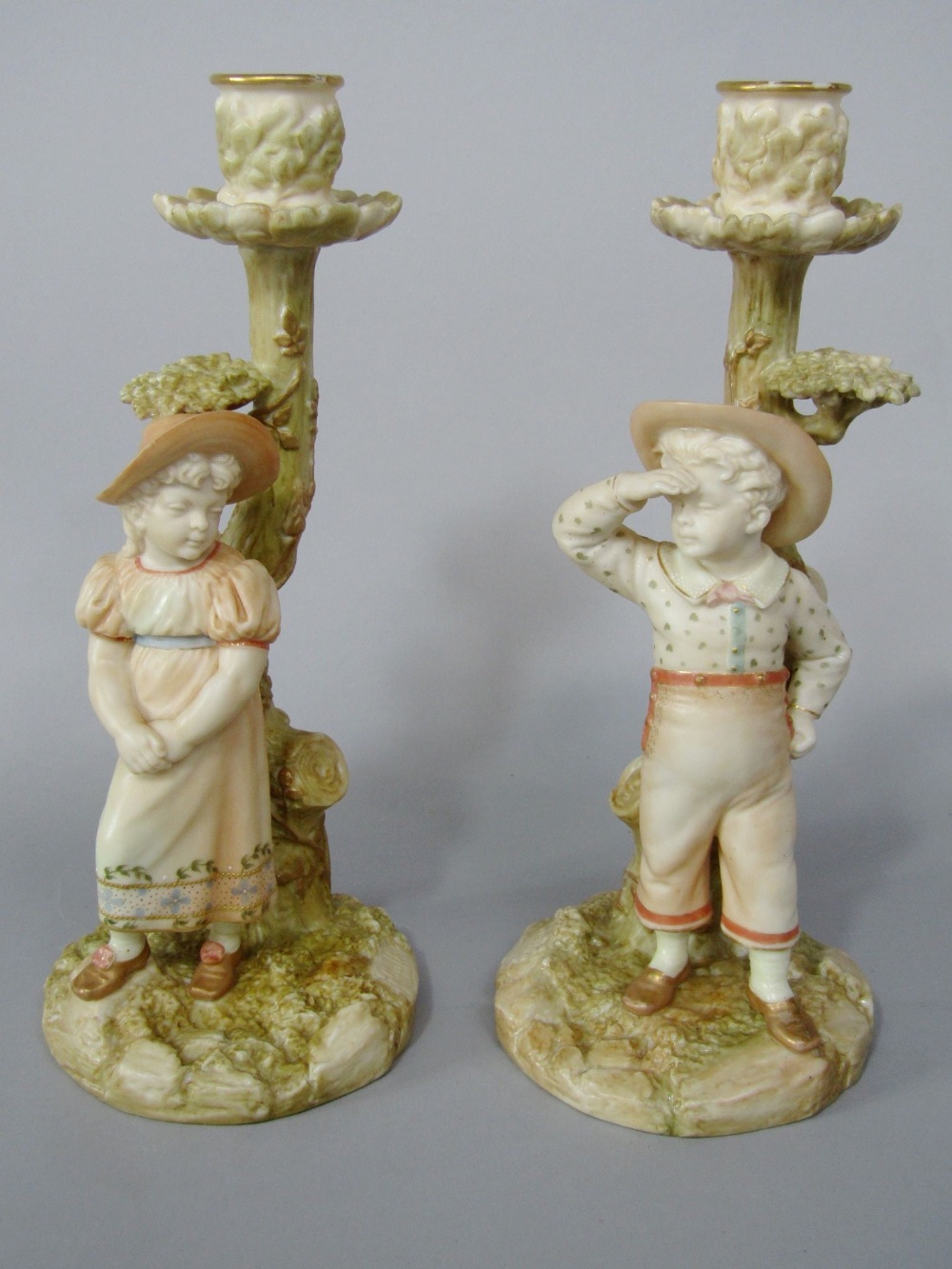 A pair of Victorian Royal Worcester candlesticks by James Hadley, both in the form of tree trunks