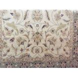 Indian vegetable dye rug decorated with scrolled foliage upon a beige ground, 250 x 160cm