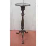 An Edwardian mahogany torchere, the circular top raised on a vase shaped pillar and tripod base,