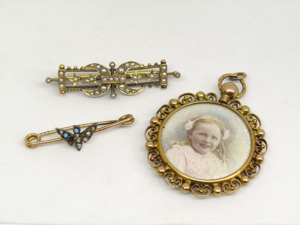 15ct circular picture pendant with scrolled border, together with a yellow metal and seed pearl