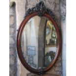 A good Victorian mahogany framed oval wall mirror enclosing a bevelled edge plate, the moulded