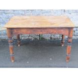 A Victorian pine kitchen table of rectangular form with end frieze drawer, raised on four ring and