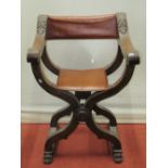 X frame folding chair with carved foliate detail, strap back and seat, lions paw feet
