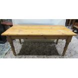 A Victorian style stripped pine farmhouse kitchen table of rectangular form, with end frieze drawer,