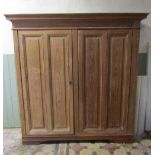 A 19th century pitch pine freestanding side cupboard enclosed by a pair of rectangular fielded