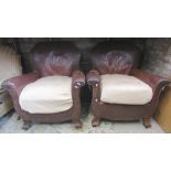 A pair of 1930s armchairs upholstered in brown leather with shaped outline and swept supports
