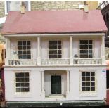 A vintage painted wooden dolls house with balustrade, columns and hinged front enclosing fur main