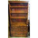 An Ercol medium elm floor standing side cupboard/dresser. the lower section enclosed by a pair of