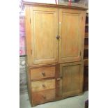 A 19th century stripped pine side cupboard in two possibly associated section, the upper enclosed by