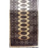 Bokhara runner with geometric medallion decoration upon a fawn ground, 280 x 75cm
