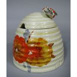A Clarice Cliff Rhodanthe type pattern honey pot and cover in the form of a bee skep with yellow and