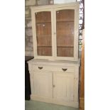 A pine chiffonier enclosed by a pair of rectangular panelled doors beneath a long drawer and