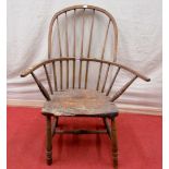 An antique Windsor comb back elbow chair in mixed timbers, on turned supports