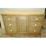 A Victorian stripped pine kitchen dresser, partially enclosed by a central panelled door, flanked by