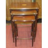 A nest of three graduated Edwardian mahogany occasional tables, on slender turned supports, with