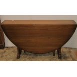 A Ercol medium elm slender, oval drop leaf, gateleg dining table, raised on chamfered supports and