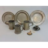 Three old pewter plates, three mugs and a small chamberstick, together with a small quantity of