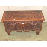 A carved oak coal box with deep carved foliate and green man detail, hinged lid and removable tin