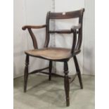A Windsor mixed wood bar back elbow chair with saddle shaped seat raised on turned supports and