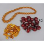 Quantity of amber coloured beads together with two costume bead necklaces (one for re-stringing)