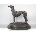 Cast bronze study of a standing greyhound upon an oval black marble base, 29 cm long