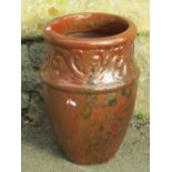 A glazed planter of circular waisted form, the drawn neck with repeating scrolling foliate detail,