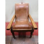 A teakwood plantation chair with extendable arms and hide upholstered seat and back, on turned