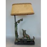 Cast bronze figural table lamp in the form of a dog looking at fruiting vines in a tree with