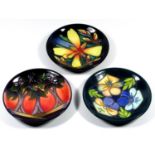 THREE MOORCROFT POTTERY COLLECTORS CLUB PIN DISHES, TUBELINED AND DECORATED WITH FLORAL DESIGNS,