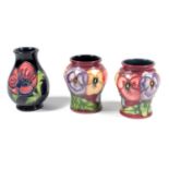 A PAIR OF MOORCROFT POTTERY SMALL URN SHAPED VASES TUBELINED AND DECORATED IN THE 'PANSY' PATTERN,
