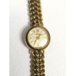 A LADY'S 14 CT GOLD TISSOT BRACELETWATCH WITH A CIRCULAR DIAL ARABIC 12 AND BATON MARKERS