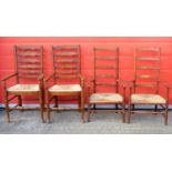 A PAIR OF 19TH CENTURY OPEN ARM LADDERBACK CHAIRS EACH WITH A RUSH DROP IN SEAT ON TURNED TAPERING