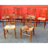 A SET OF SIX COUNTRY CHAIRS EACH WITH A PIERCED SPLAT BACK INCLUDING TWO WITH ARMS AND RUSH SEATS.