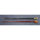 AN EBONISED KNARLED WALKING CANE WITH A BRASS CLASSICAL GIRLS' BUST HANDLE (L. 85.5 CM) AND A