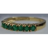 YELLOW METAL AND EMERALD RING STAMPED 18 KT AND 750, SIZE N 1/2, SET SEVEN EMERALDS, GROSS WEIGHT