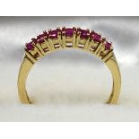YELLOW METAL AND RUBY RING STAMPED 18 KT AND 750, SIZE N 1/2, SET SEVEN RUBIES, GROSS WEIGHT 2.6
