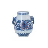 A blue and underglaze red porcelain vase, decorated with flowers. The handles in the shape of